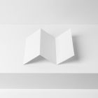 Front view, white Trifold Mockup arranged in the letter z laying on the white box.