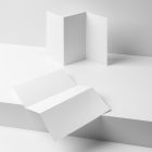View from above, at a 45-degree angle of two white Trifold Mockups. Both of them are laying on the white boxes.