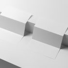 View from above, at a 45-degree angle of two white Trifold Mockups arranged in the letter z and laying on two white boxes.