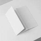 View from above, at a 45-degree angle of white Trifold Mockup arranged in the letter z laying on a white box.