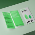 View from above, at a 45-degree angle of a two Trifold Mockups laying on a light green box. One is close and showing green graphic illustration with typography. The second is opened and shows what is inside the brochure.