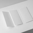 View from above, at a 45-degree angle of a two white Trifold Mockups laying on a white box.