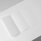 View from above, at a 45-degree angle of an open white Trifold Mockup laying on a white box.