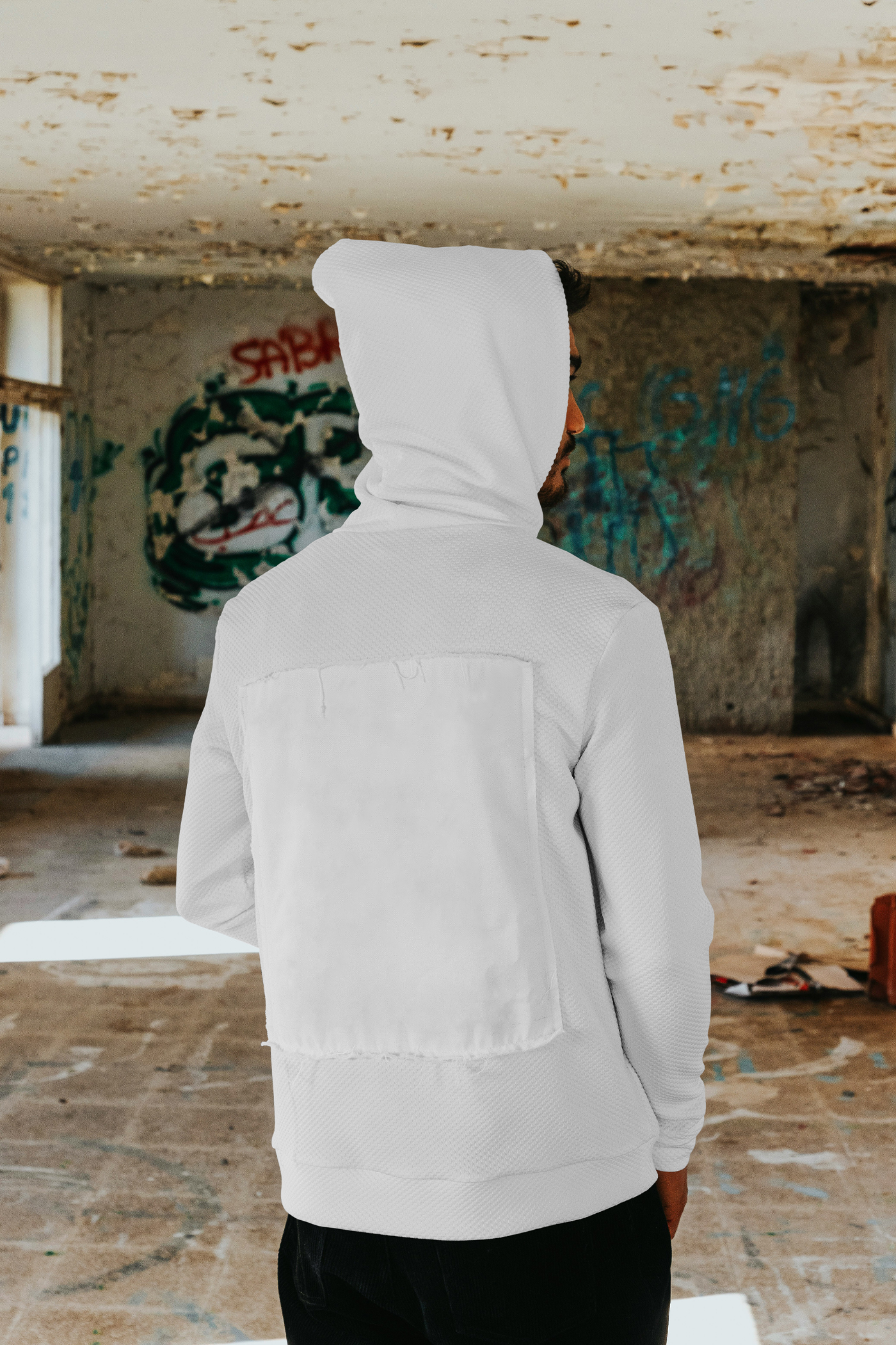 Front view, standing men backwards wearing white hoodie mockup between dirty space area.