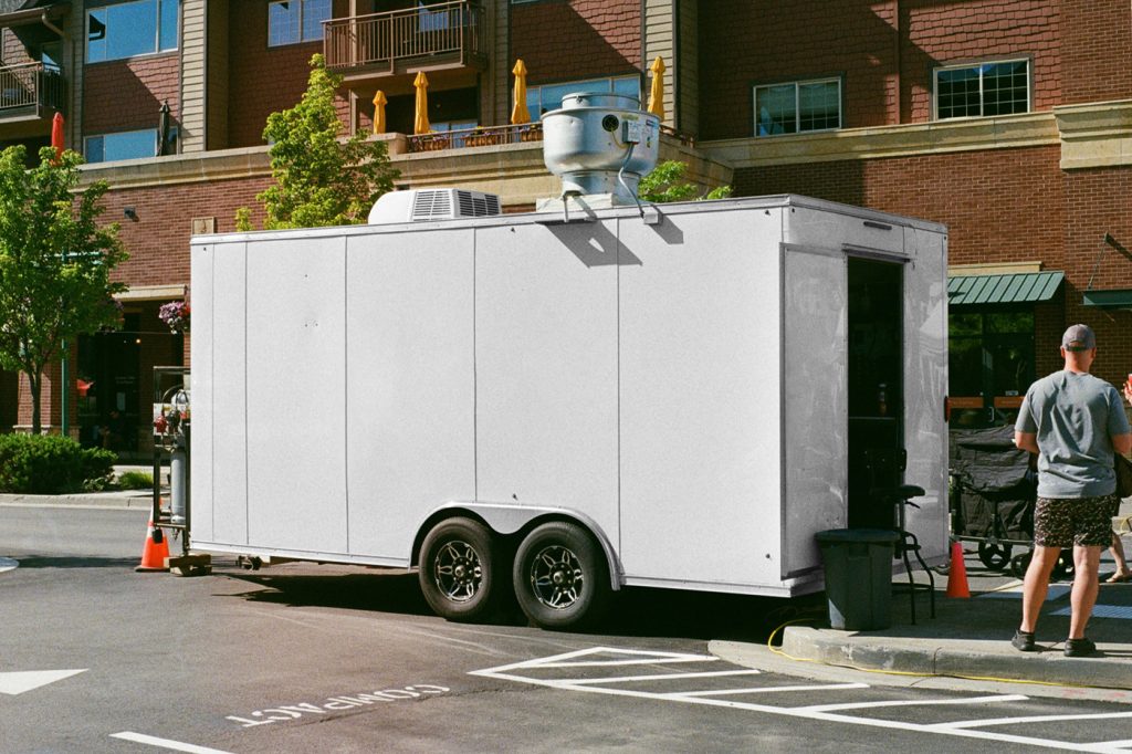 Standing white truck trailer mockup on the street in front of the building.