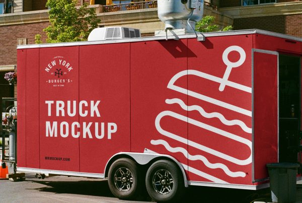 Standing red truck trailer mockup on the street with logo and white design in front of the building.