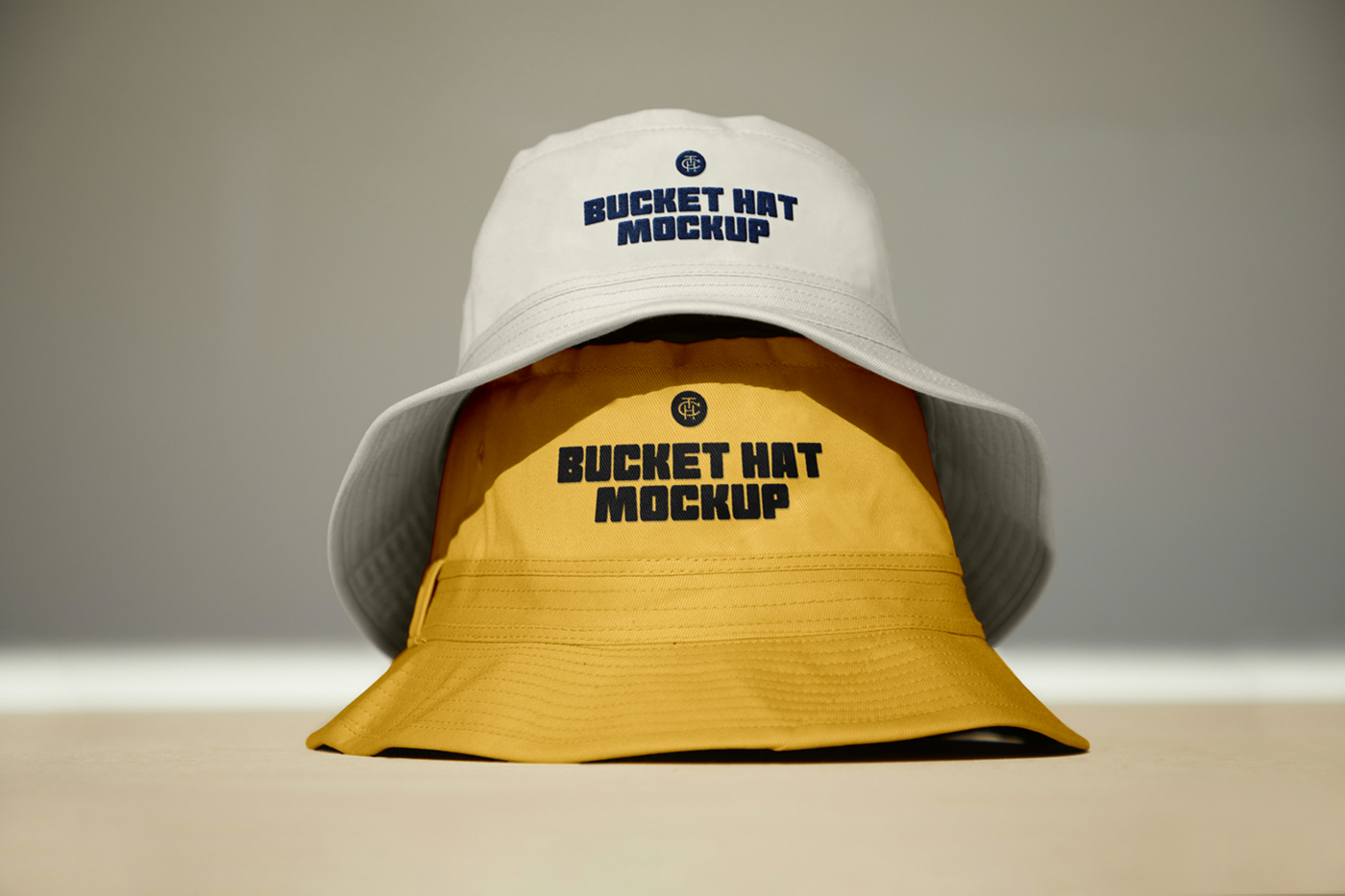Front view, two bucket hat mockups stacked on top of each other laying on the floor.