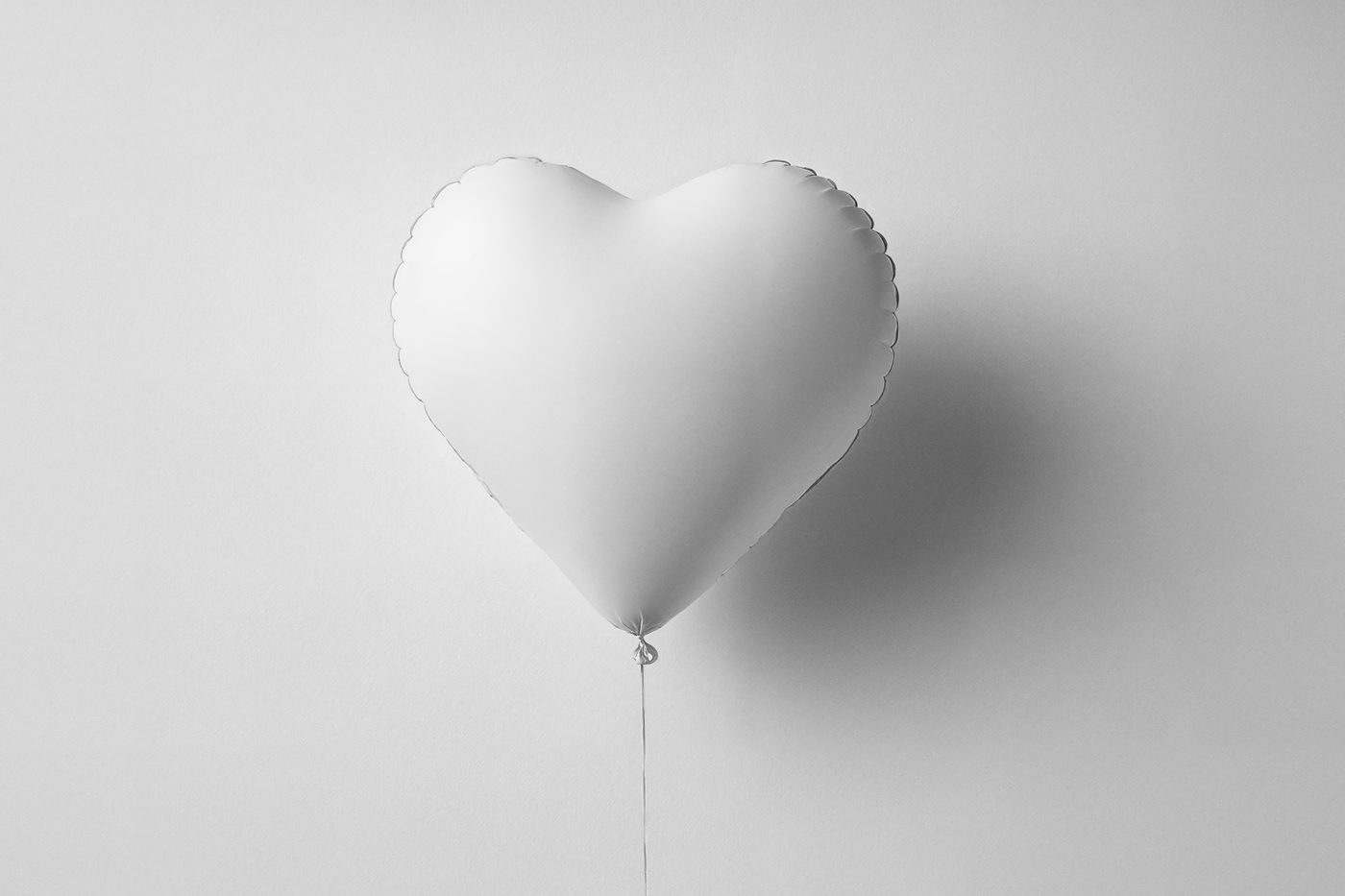 Front view, Valentine's Day blank heart balloon mockup right in front of the white wall.