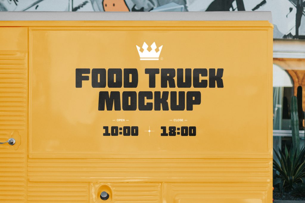 Front view, yellow food truck mockup with black typography design standing right in front of the building.