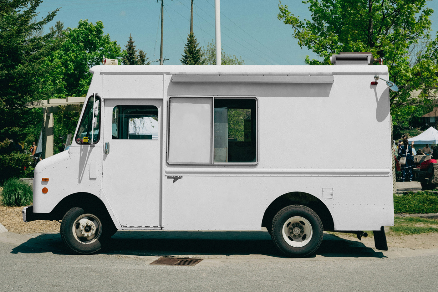 Front view, white vintage food truck mockup standing in the parking lot near the festival