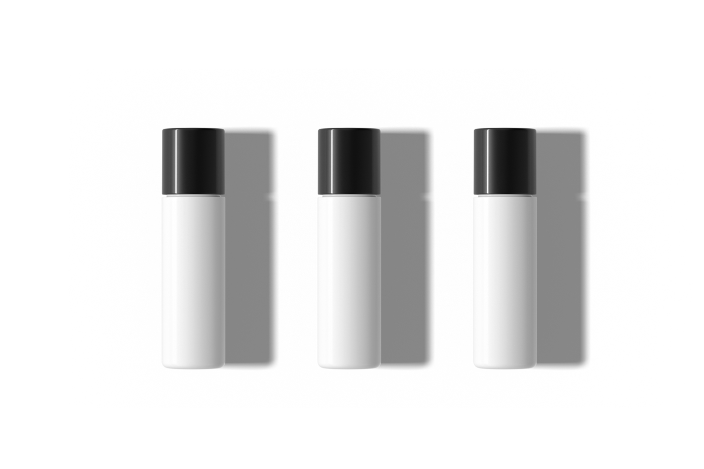 View from above, three slender ones white bottle mockups laying on the white floor.