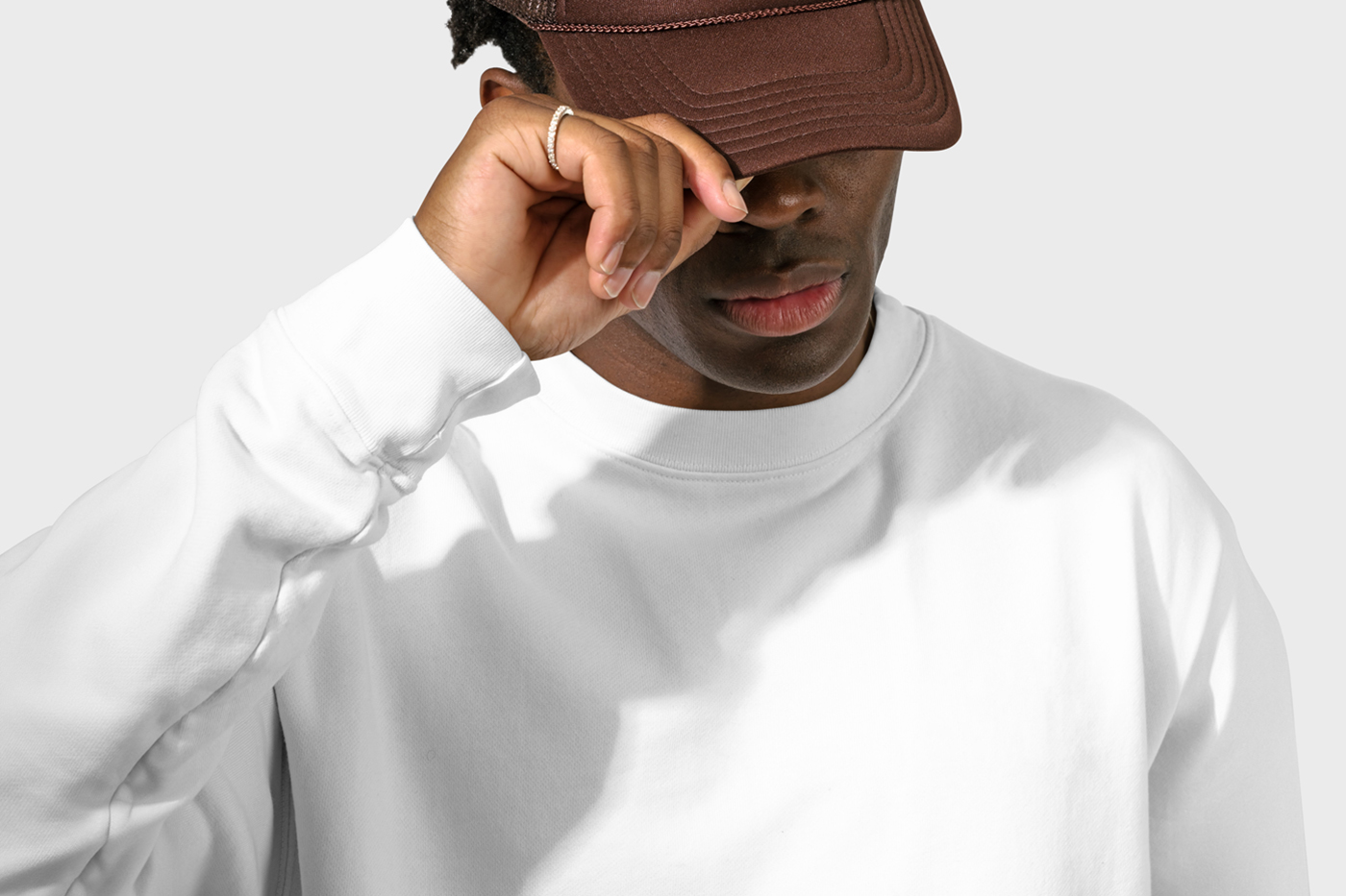 Standing men wearing a blank Sweatshirt Mockup in front of the white wall.