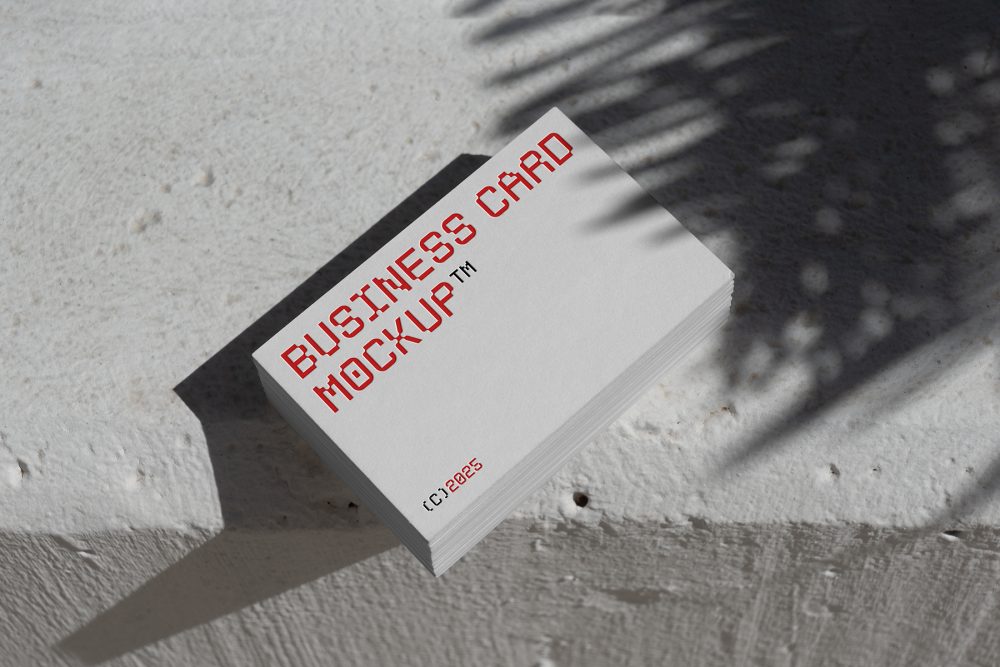 View from above, outdoor business card mockup with red and white colors, geometric typography design laying on the white color concrete.