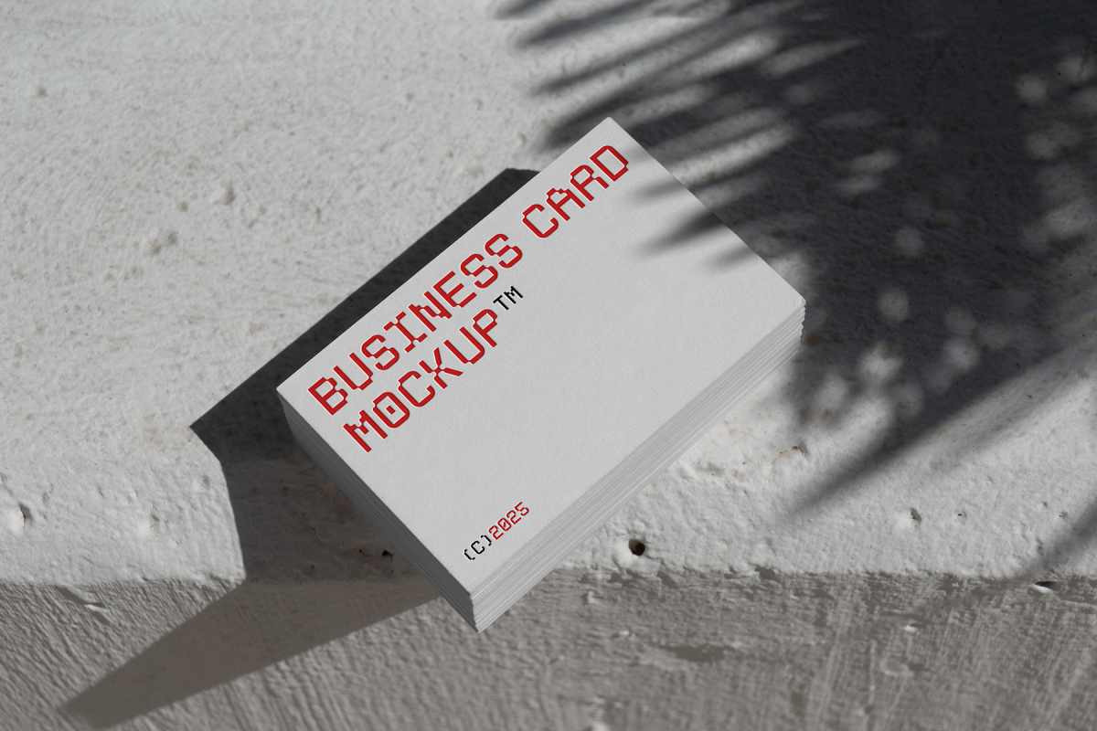 View from above, outdoor business card mockup with red and white colors, geometric typography design laying on the white color concrete.