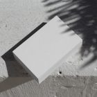 View from above, blank outdoor business card mockup laying on the white color concrete.