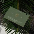 View from above, outdoor business card mockup with green and gold design colors, laying on the coniferous branch.