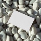 View from above, single blank outdoor business mockup laying lies on the pebbles.