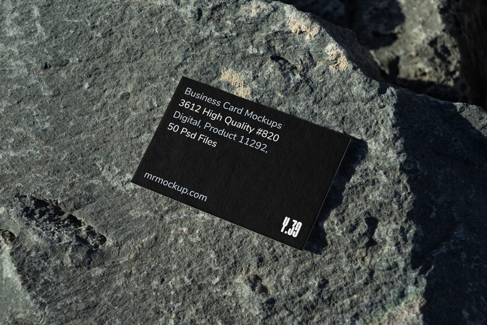 View from above, single outdoor business card mockup with blue and black colors, strong typography design, laying on massive stone.