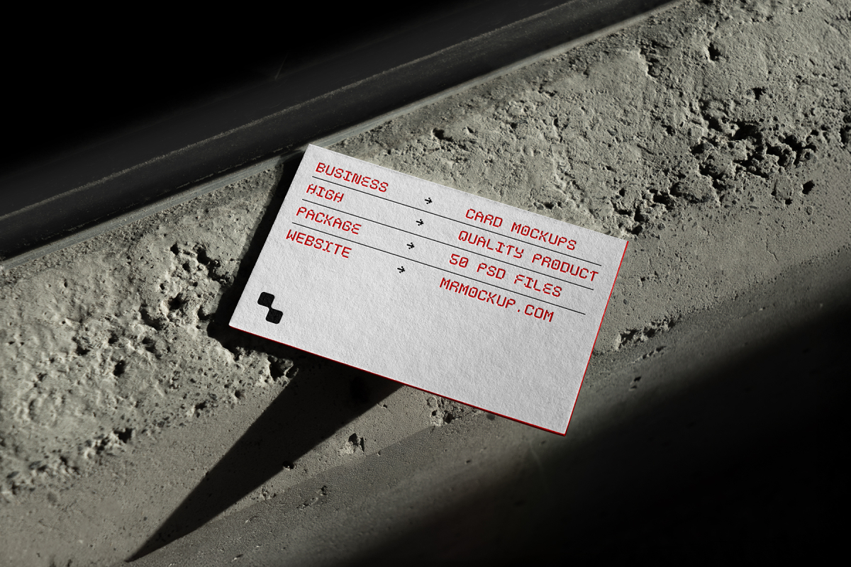 View from above, single outdoor business card mockup with red and black colors, geometric typography design, laying on the concrete.