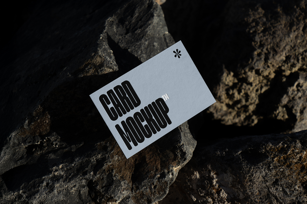 View from above, single outdoor business card mockup with blue and black colors, strong typography design, laying on massive stone.