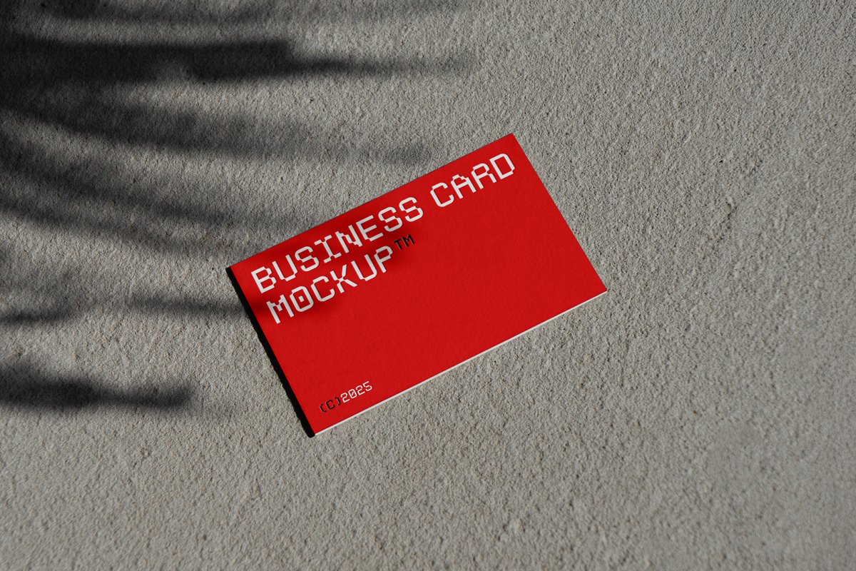 View from above, single outdoor business card mockup with red and white colors, geometric typography design, laying on concrete.