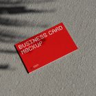 View from above, single outdoor business card mockup with red and white colors, geometric typography design, laying on concrete.