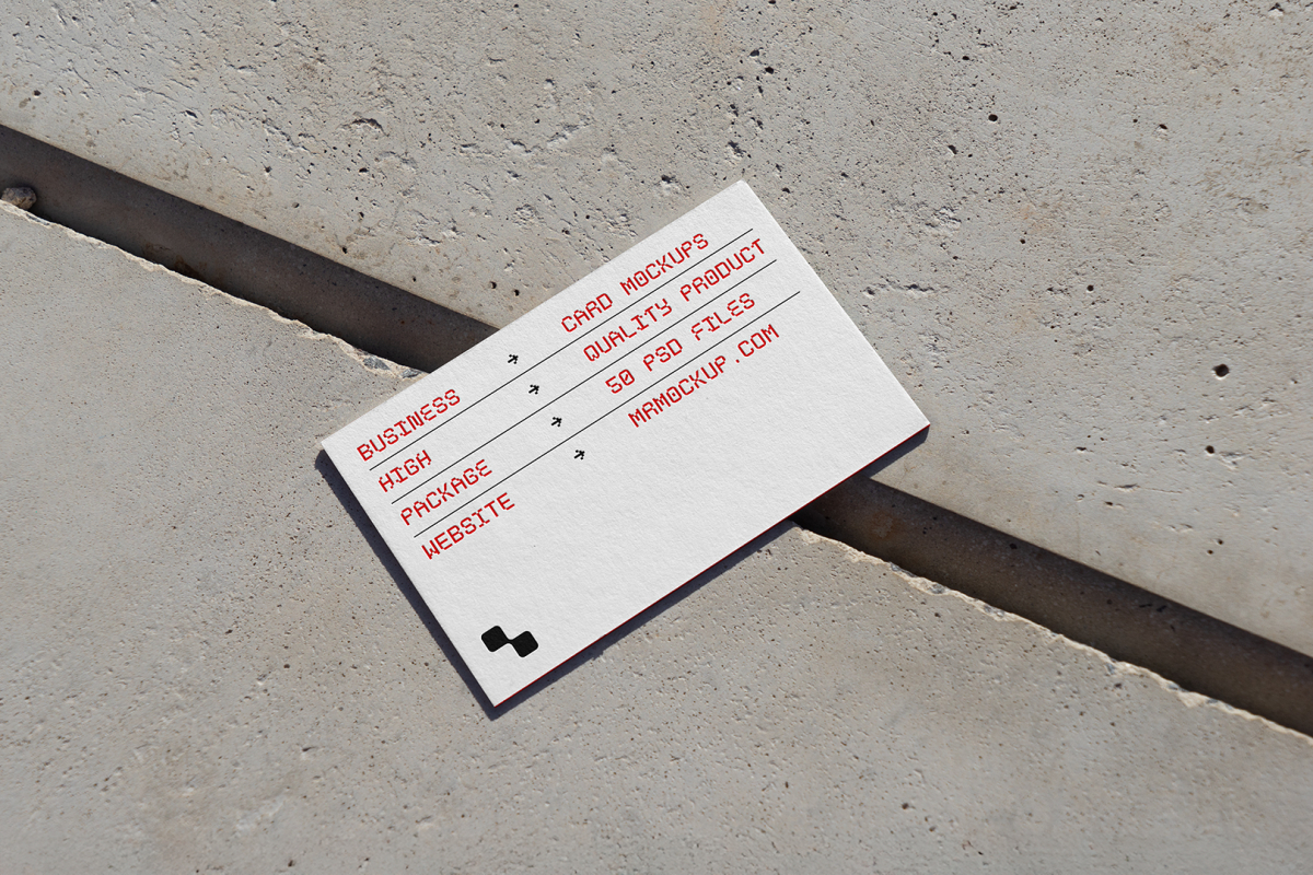 View from above, single outdoor business card mockup with red and black colors, geometric typography design, laying on concrete.