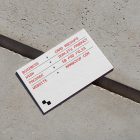 View from above, single outdoor business card mockup with red and black colors, geometric typography design, laying on concrete.