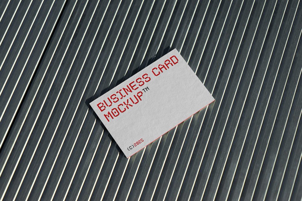 View from above, single outdoor business card mockup with red and white colors, geometric typography design, laying on roof tiles.