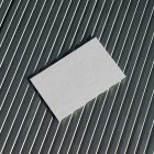View from above, a single blank outdoor business card mockup laying on roof tiles.