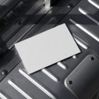 View from above, a single blank outdoor business card mockup laying on an aluminum Rimowa brand suitcase.