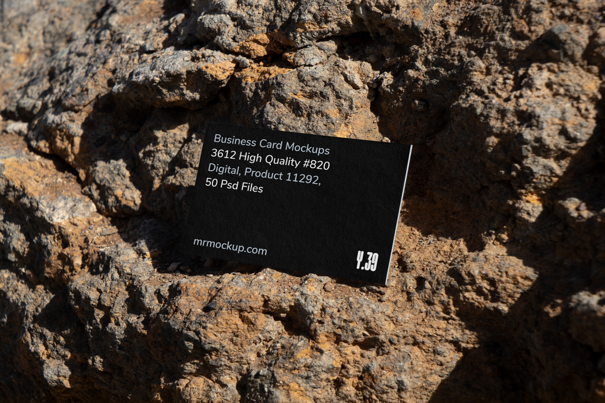 View from above, single outdoor business card mockup with blue and black colors, strong typography design, laying on massive stone.