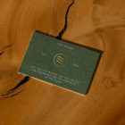 View from above, single outdoor business card mockup with green and gold colors, serif typography design, laying on the wooden background.