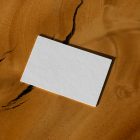 View from above, a single blank outdoor business card mockup laying on the wooden background.