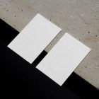 View from above, two blank outdoor business card mockups laying on the concrete.