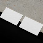 View from above, two blank outdoor business card mockups laying on the concrete.