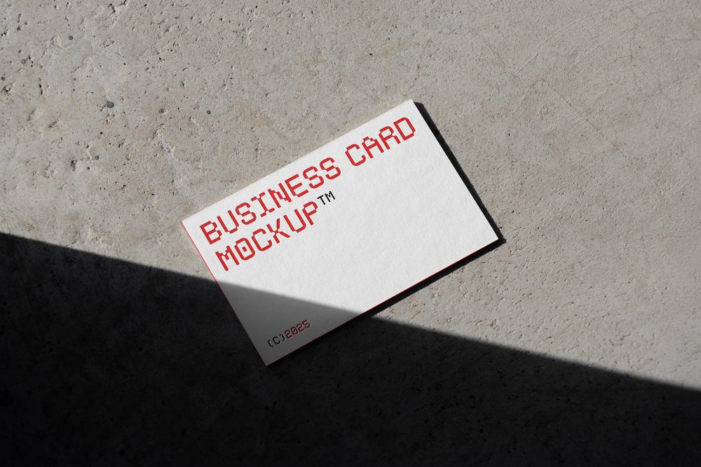 View from above, a single outdoor business card mockups with red and white colors, geometric typography design, laying on the concrete.