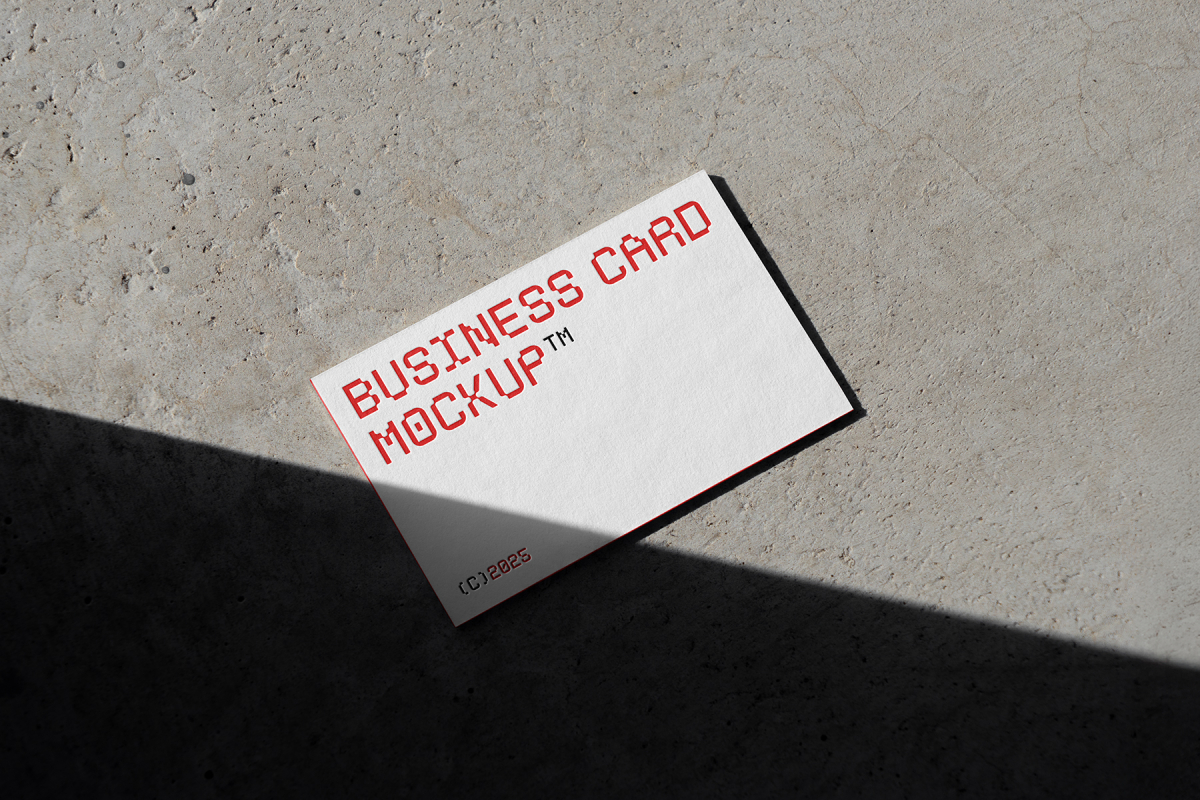 View from above, a single outdoor business card mockups with red and white colors, geometric typography design, laying on the concrete.