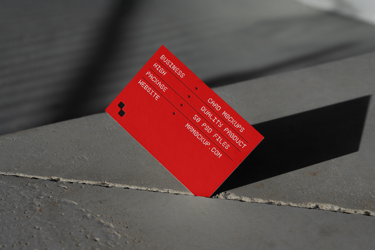 Front view, single outdoor business card mockup with red and white colors, geometric typography design, pressed into the crack of concrete.