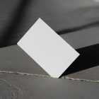 Front view, a single blank outdoor business card mockup pressed into the crack of concrete.