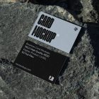 View from above, two outdoor business card mockups with blue and black colors, strong typography design, laying on massive stone.
