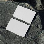 View from above, two blank outdoor business card mockups laying on massive stone.