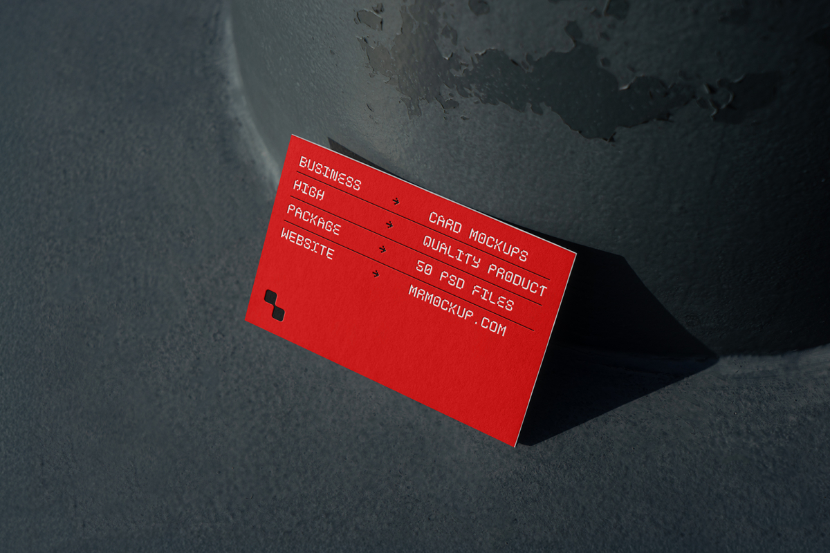 Front view, single outdoor business card mockup with red and white colors, geometric typography design, leans against a pole.