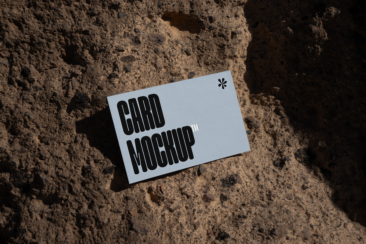 View from above, single outdoor business card mockup with blue and black colors, strong typography design, laying on massive stone.