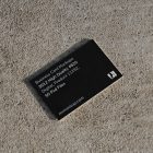 View from above, single outdoor business card mockup with blue and black colors, strong typography design, laying on the sand background.