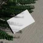 View from above, a single blank outdoor business card mockup laying on the sand background.