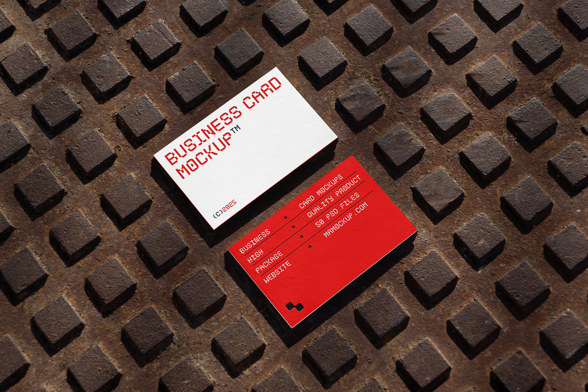 View from above, two outdoor business card mockups with red and white colors, geometric typography design, laying on street manhole.