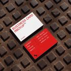 View from above, two outdoor business card mockups with red and white colors, geometric typography design, laying on street manhole.