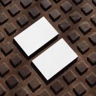 View from above, two blank outdoor business card mockups laying on street manhole.