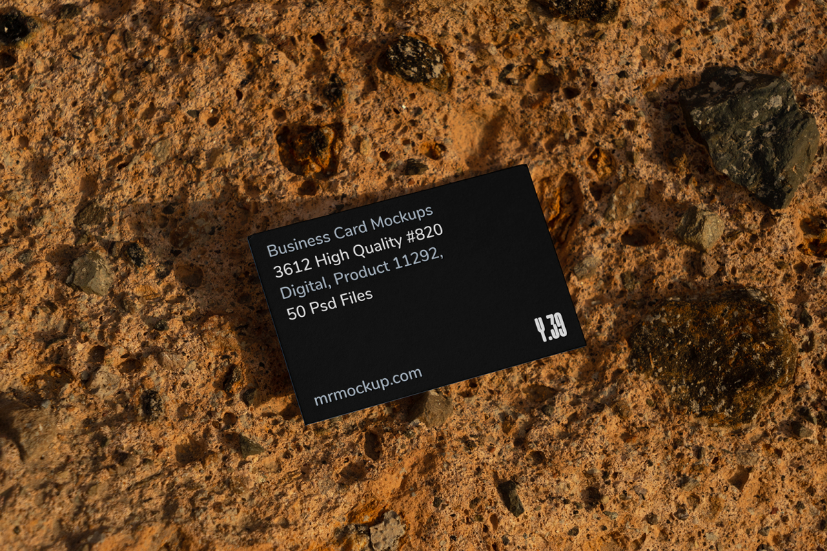 View from above, single outdoor business card mockup with blue and black colors, strong typography design, laying on massive stone.